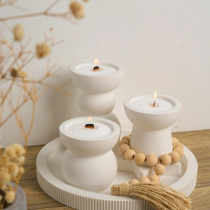 Minimalist white geometric candle holder set with wood wicks on a textured tray
