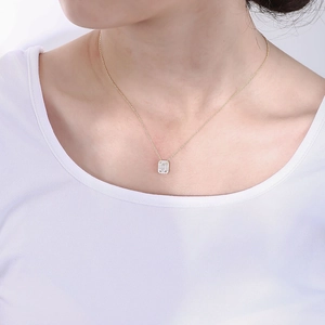 Close-up of elegant gold rectangle zircon pendant necklace worn by a female model