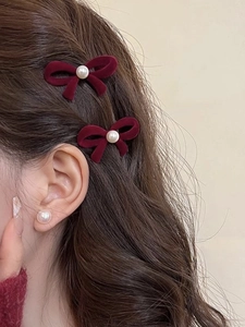 Detail view of red velvet bow hair clips with pearls and matching earrings
