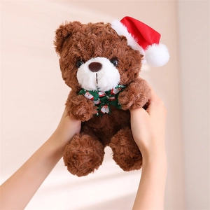 Detailed view of a brown plush teddy bear wearing a Christmas hat and a festive green bow