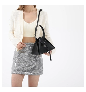 Detail of a black triangular punk crossbody bag with metallic charms and long shoulder strap