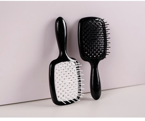 Detailed view of hollow grid hairbrushes in black and white with cushioned bristles