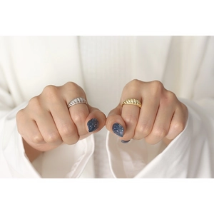 Detail of twisted rope ring stack in gold and silver finish on model finger