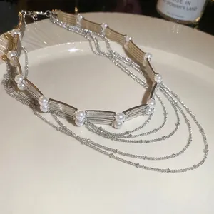 Collier de perles multicouches élégant avec chaînes argentées sur une assiette en céramique