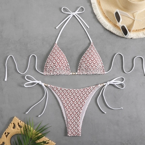 Detailed flat lay of white bikini with red heart prints and pearl buckle accents