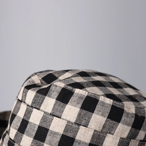 Macro shot of black and white checkered linen fabric texture on a flat top sun hat
