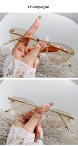 Detail of rimless champagne cat-eye sunglasses with gold metal frame and crystal F accent