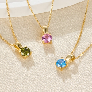 Macro detail of 925 silver gemstone necklaces in green, pink and blue with gold finish