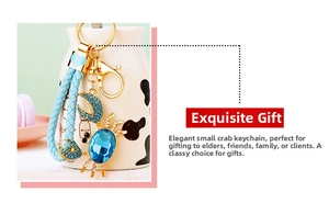 Detail of a sparkling golden crab keychain with deep blue crystals and sky blue braided cord