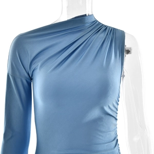 Detail view of royal blue one-shoulder dress with elegant pleats and long sleeve design