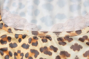 Gros plan sur l'imprimé léopard et la dentelle nuage bleu clair d'une robe ajustée