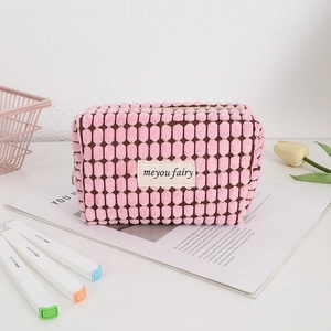 Neceser de pana rosa con diseño de burbujas en un entorno de escritorio elegante