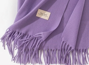 Detailed texture of purple cashmere-like scarf showing soft knit fabric and long fringe