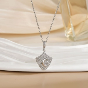 Elegant shield necklace with crescent moon and clear zircon stones in silver tone