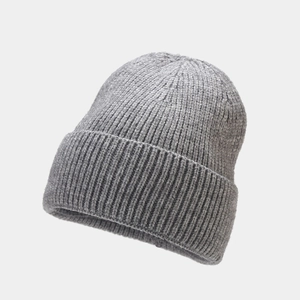 Macro detail of the grey ribbed knit texture and folded cuff on this warm winter beanie