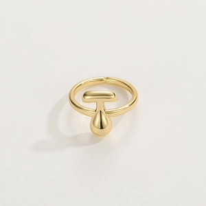 Detail of 18K gold-plated open ring with a polished T-shaped pendant on white background