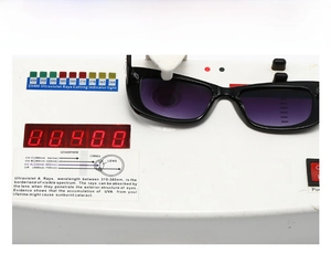 Detail of small square sunglasses showing UV400 protection testing on a digital device