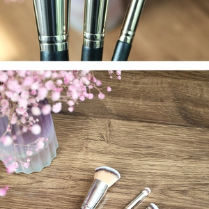 Flat lay of foundation and concealer brushes with gradient bristles on a wood surface