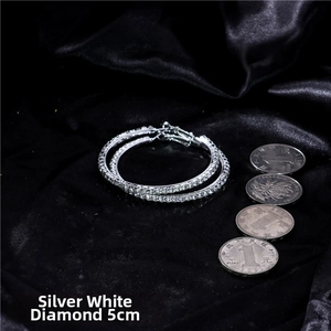 Detailed view of 5cm silver hoop earrings with white zircon on a black velvet background