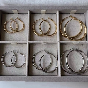 Gold and silver chunky hoop earrings in three sizes displayed on a velvet jewelry tray