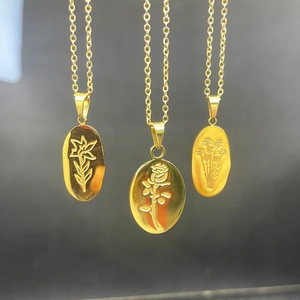Detailed view of three gold oval flower pendants featuring lily and rose engravings