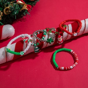 Detailed view of Christmas themed beaded bracelets with Santa and tree charms on candy cane