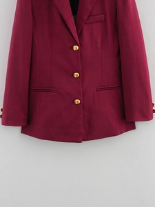 Close-up of wine red longline blazer with golden buttons and twill fabric detail