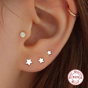 Close-up of S925 sterling silver star studs and round crystal earrings on ear