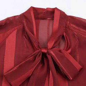 Elegant red bell sleeve blouse with shimmering pinstripes and a tie-neck design
