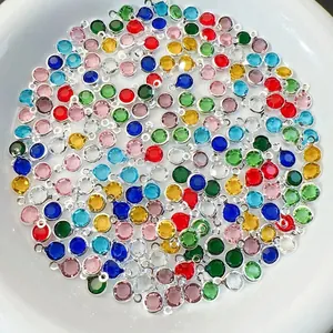 Macro shot of colorful round faceted glass charms with silver plated copper edges for DIY jewelry