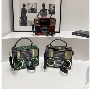 Three retro radio-shaped acrylic crossbody bags displayed on a white tiered stand