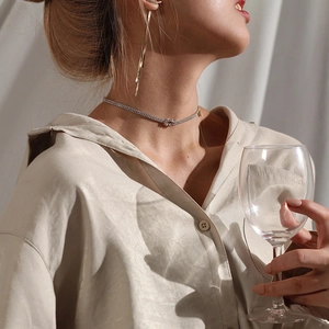 Elegant rhinestone choker with bow design and matching long tassel earrings set on a model