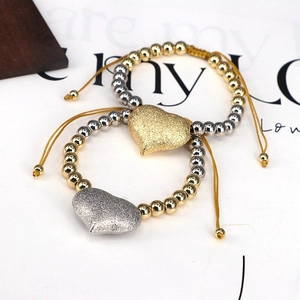 Detail of adjustable beaded bracelet with frosted heart pendant in gold and silver