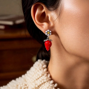 Detailed close-up of strawberry drop earrings with pearls and crystals on a model