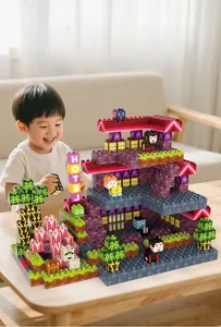 Garçon asiatique jouant avec un jeu de blocs de construction hôtel sur un canapé
