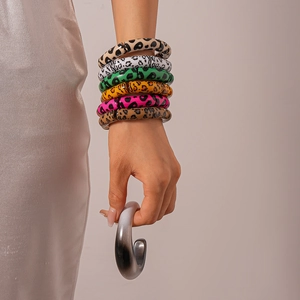 Detail of colorful acrylic leopard print bangles with polished resin finish on model