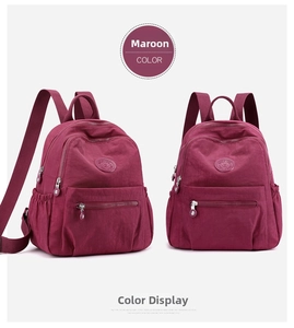 Detailed view of dark red nylon backpack showing main zipper and side pockets