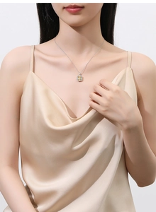 Detail shot of a rectangular yellow gemstone necklace on S925 silver chain worn by a model