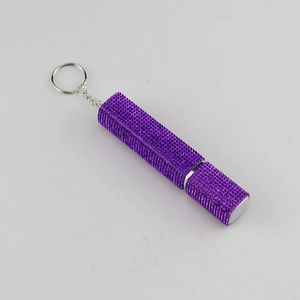 Detail view of purple rhinestone encrusted refillable perfume bottle with silver keychain