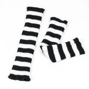 Detailed close-up of black and white striped knitted leg warmers in a flat lay view