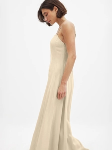 Side view detail of a beige maxi dress featuring fine straps and seamless side zipper