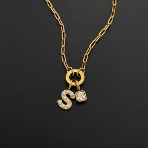 Dettaglio della collana in acciaio dorato con ciondolo a lettera S di perle e cristallo