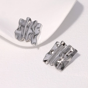 Close-up of silver-plated irregular pleated rectangle earrings in a minimalist style