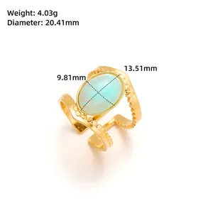 Close-up of gold V-shaped ring with green natural stone and beaded border details