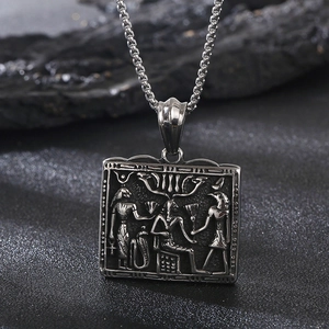 Macro shot of silver square pendant with detailed ancient Egyptian relief and symbols