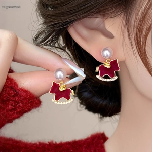 Detail view of red flocked rocking horse earrings with pearls and crystal accents