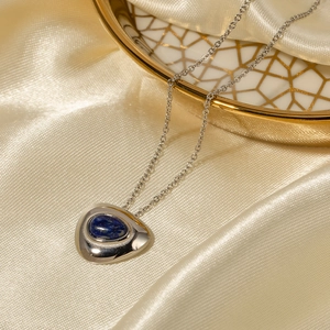 Detail of silver titanium necklace featuring a triangle pendant with blue lapis lazuli stone