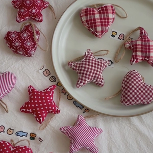 Detailed view of handmade Christmas fabric heart and star ornaments with red patterns