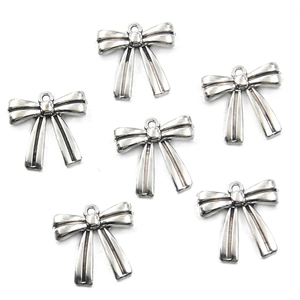 Detail showing six silver bow-shaped alloy pendants for DIY necklace and bracelet crafting