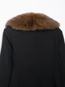 Detail view of the back of a black wool coat featuring a large brown faux fur collar